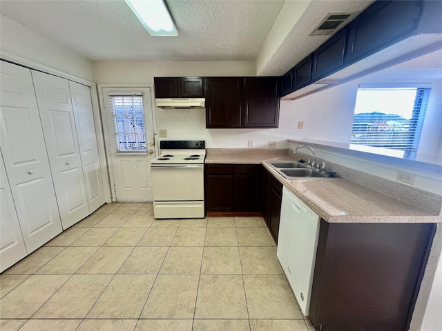 kitchen with a textured ceiling, sink, a healthy amount of sunlight, and white appliances