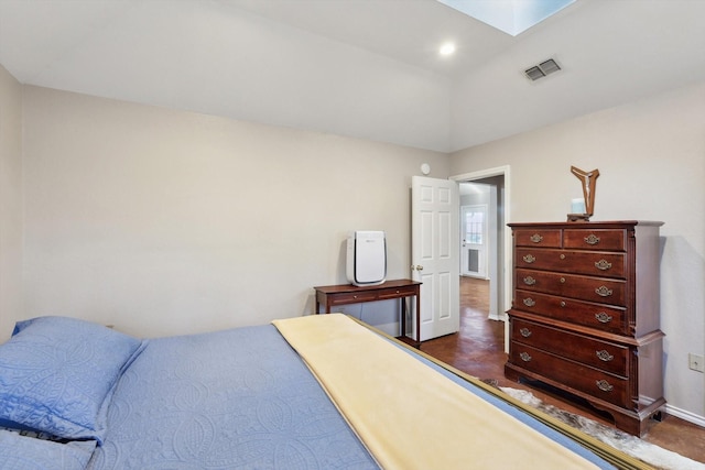 bedroom featuring a skylight and dark wood-type flooring