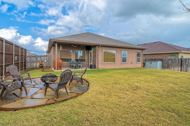 back of property with a fire pit, a lawn, ceiling fan, central AC, and a patio