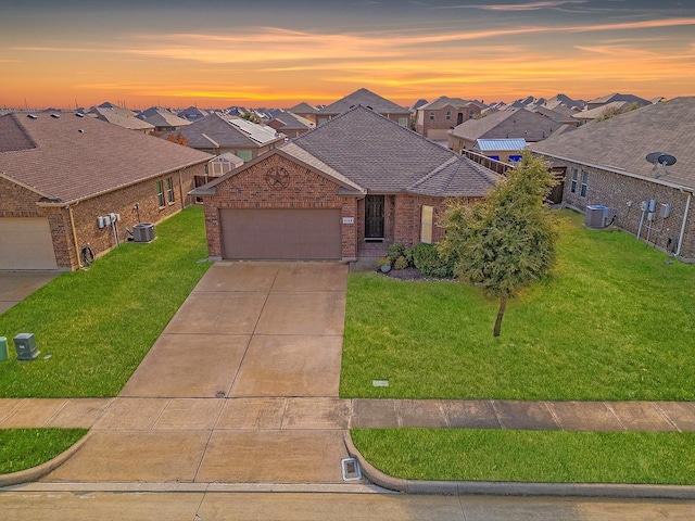 ranch-style home featuring a lawn and central AC unit