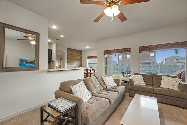 carpeted living room with ceiling fan