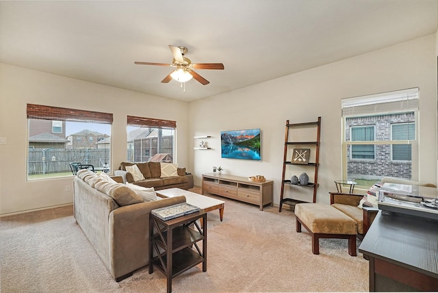 carpeted living room with ceiling fan and plenty of natural light