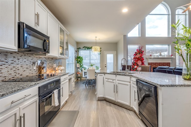 kitchen with black appliances, white cabinets, and sink