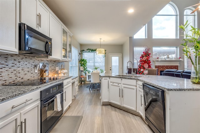 2712 Thorncreek Ln, Fort Worth, TX 76177 - kitchen with black appliances, healthy amount of natural light, light wood-type flooring, white cabinets, and recessed lighting