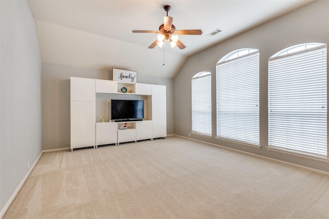 unfurnished living room with light colored carpet, plenty of natural light, lofted ceiling, and ceiling fan