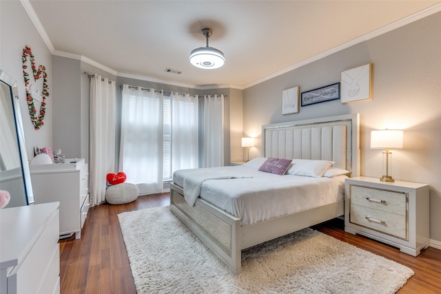 bedroom with dark hardwood / wood-style flooring and crown molding