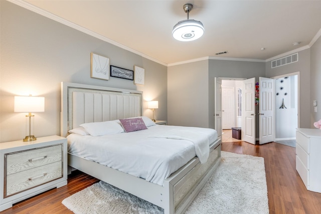 bedroom with hardwood / wood-style flooring and crown molding