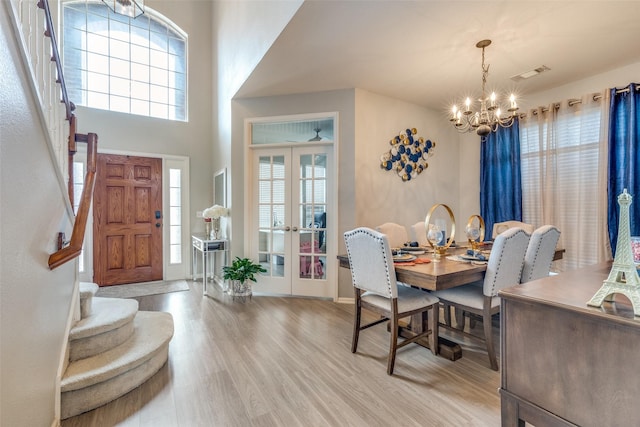 dining room with a chandelier, french doors, and light hardwood / wood-style floors