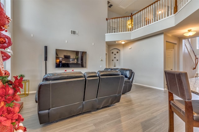 living room featuring wood-type flooring and a high ceiling