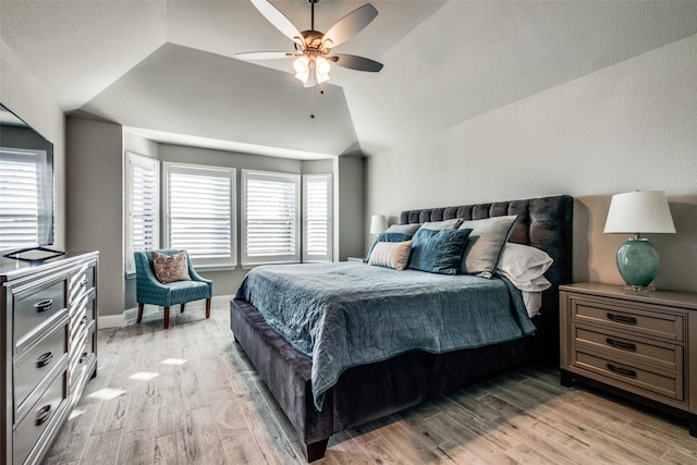 bedroom with multiple windows, ceiling fan, light hardwood / wood-style floors, and vaulted ceiling