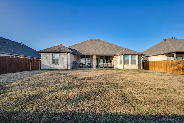 rear view of property with a yard and a patio