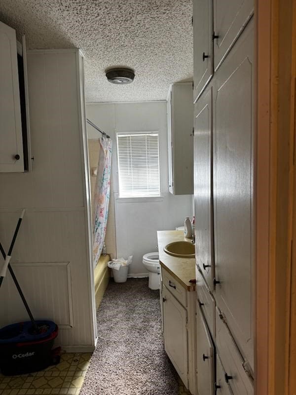 full bathroom with shower / bath combo with shower curtain, vanity, a textured ceiling, and toilet