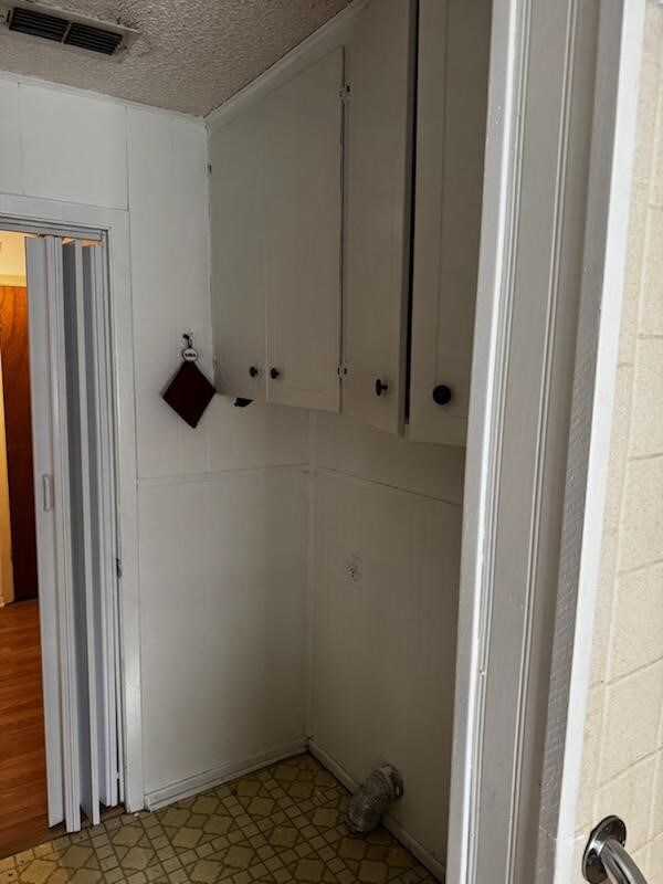 washroom featuring a textured ceiling and light wood-type flooring