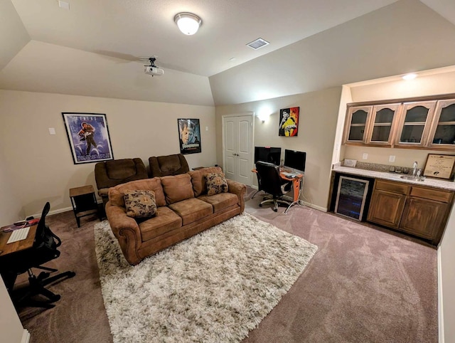 carpeted living room featuring visible vents, lofted ceiling, beverage cooler, wet bar, and baseboards