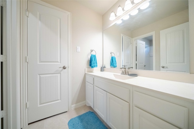 full bathroom featuring tile patterned flooring, walk in shower, vanity, and baseboards