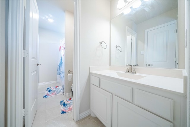 full bath with tile patterned flooring, toilet, vanity, and baseboards