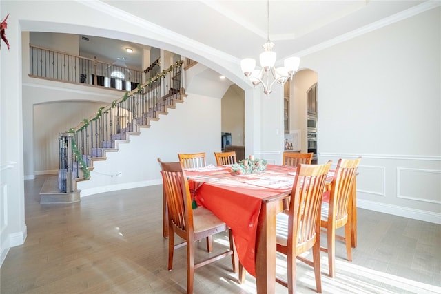 dining space featuring a tray ceiling, an inviting chandelier, and ornamental molding