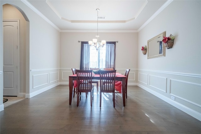 dining area with a raised ceiling, crown molding, dark hardwood / wood-style floors, and a notable chandelier