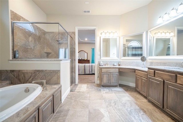 ensuite bathroom featuring vanity, a garden tub, visible vents, and a stall shower