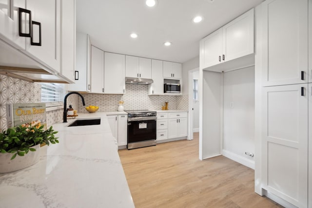 kitchen featuring light wood-type flooring, stainless steel appliances, and white cabinetry