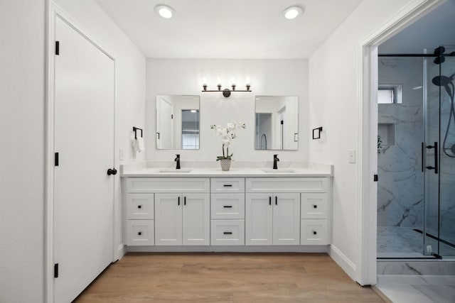 bathroom with vanity, an enclosed shower, and wood-type flooring