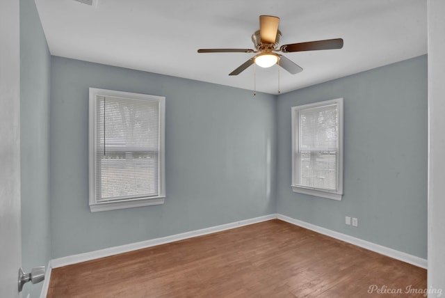 spare room with plenty of natural light, hardwood / wood-style floors, and ceiling fan