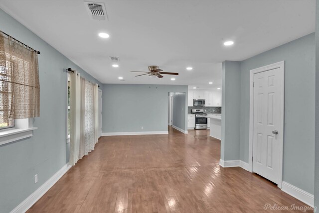 unfurnished living room with hardwood / wood-style floors and ceiling fan