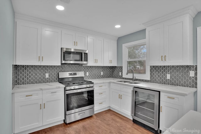 kitchen featuring wine cooler, white cabinetry, stainless steel appliances, and sink