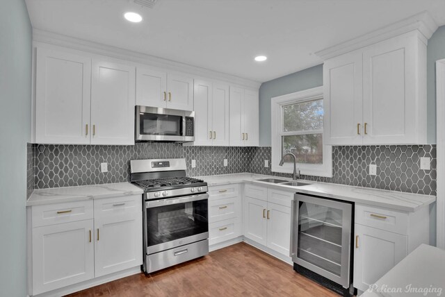 6263 Bain Blvd, Keithville, LA 71047 - kitchen with a sink, white cabinetry, appliances with stainless steel finishes, and wine cooler