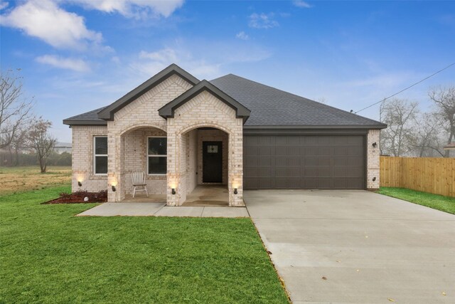 french country home with a front yard and a garage