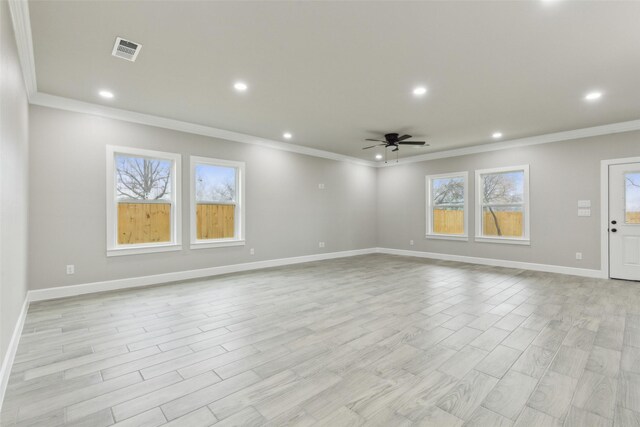 unfurnished living room with light hardwood / wood-style floors, a wealth of natural light, and crown molding