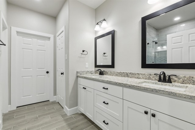 bathroom featuring a tile shower and vanity