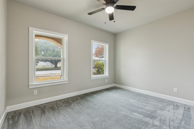 empty room featuring a wealth of natural light, carpet, and ceiling fan