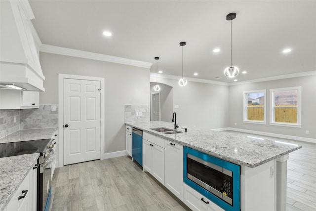 kitchen with custom exhaust hood, white cabinets, sink, appliances with stainless steel finishes, and decorative light fixtures