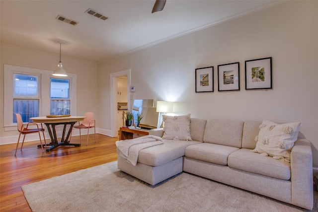 living room with wood-type flooring and ornamental molding