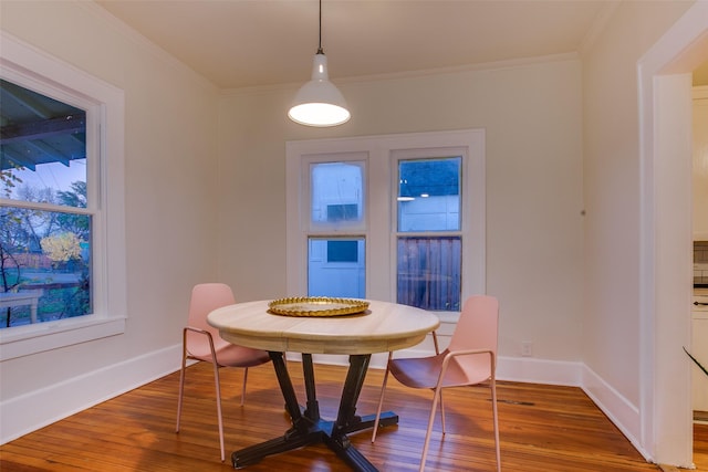 dining space with hardwood / wood-style flooring and ornamental molding