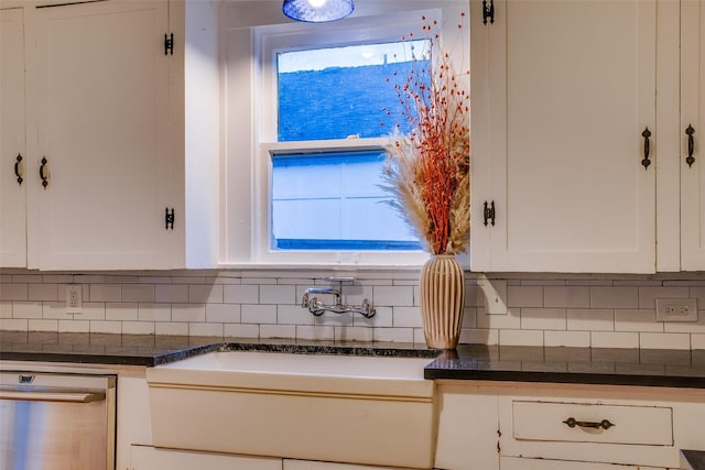 kitchen with decorative backsplash, dishwasher, white cabinets, and dark stone counters