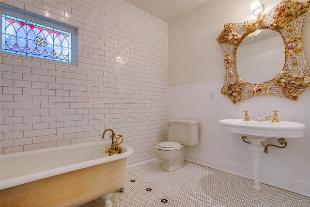 bathroom with sink, a bath, tile walls, tile patterned flooring, and toilet