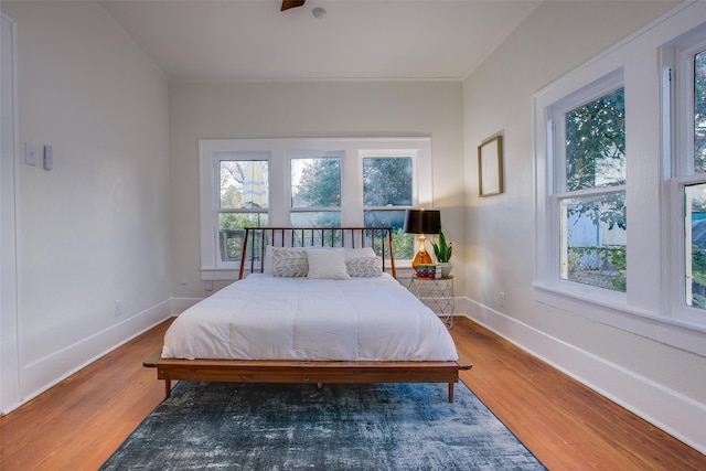 bedroom featuring ceiling fan, wood-type flooring, and ornamental molding