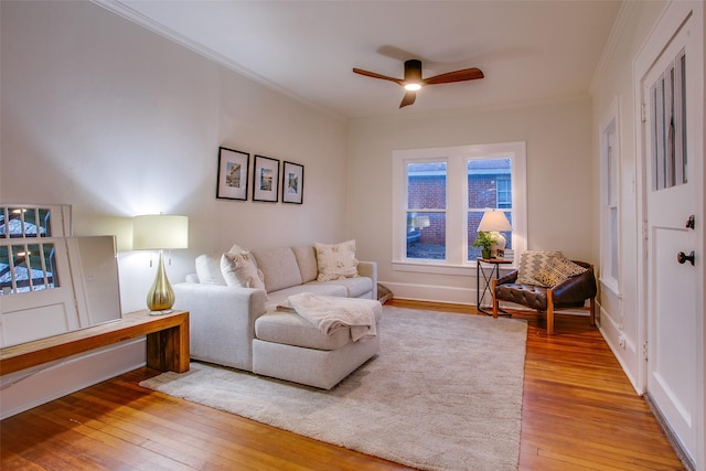 living room with ceiling fan, light wood-type flooring, and ornamental molding