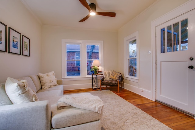 sitting room with hardwood / wood-style flooring, ceiling fan, and ornamental molding