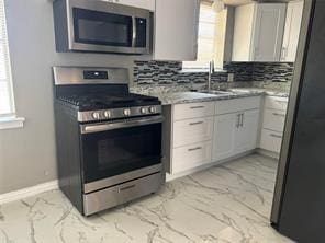 kitchen with appliances with stainless steel finishes, sink, and backsplash