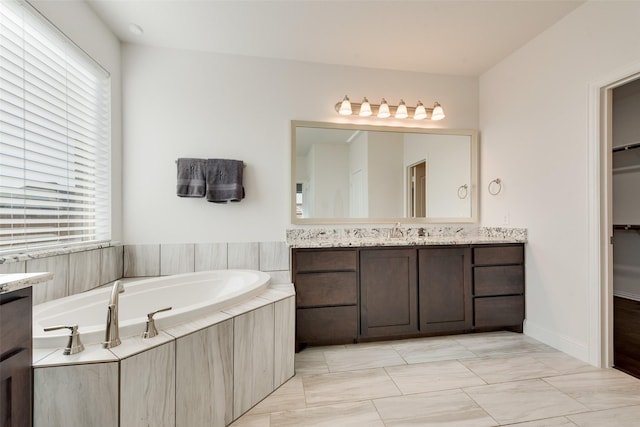 bathroom with vanity and a relaxing tiled tub