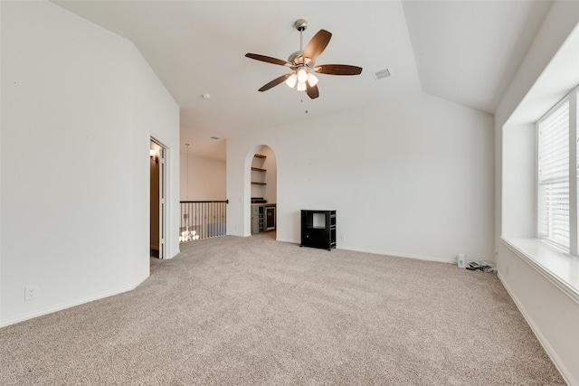 unfurnished living room featuring carpet flooring, ceiling fan, lofted ceiling, and built in shelves