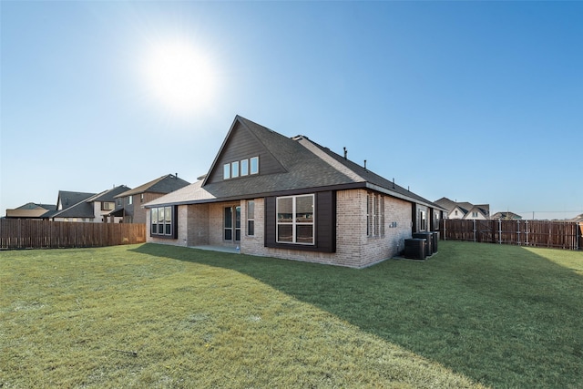 back of house featuring central AC and a lawn