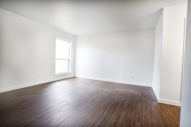 unfurnished room with dark hardwood / wood-style flooring