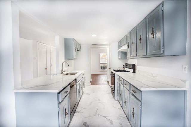 kitchen with kitchen peninsula, light wood-type flooring, light stone counters, stainless steel appliances, and sink