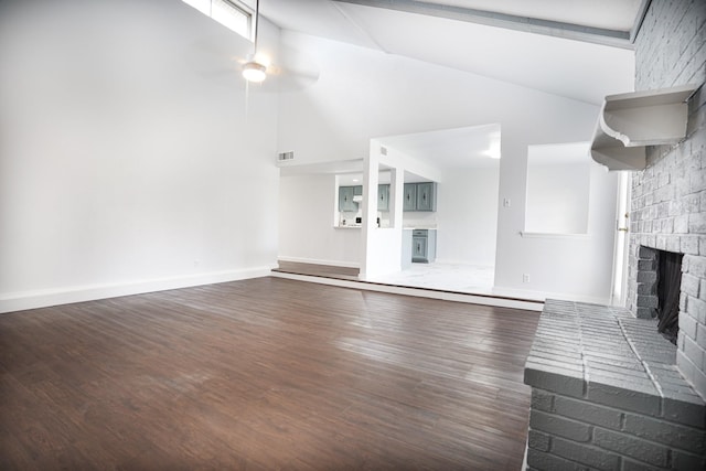 unfurnished living room with ceiling fan, a fireplace, high vaulted ceiling, and dark wood-type flooring