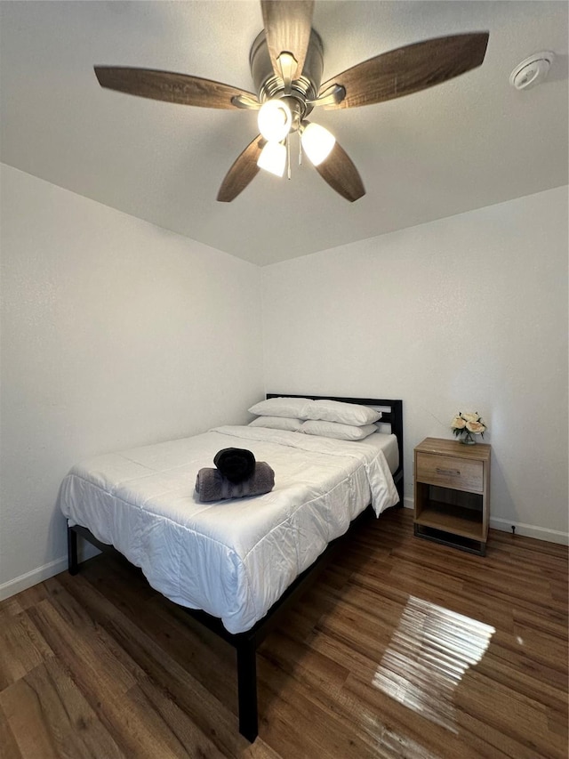 bedroom with ceiling fan and dark wood-type flooring