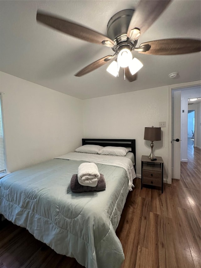 bedroom with dark hardwood / wood-style floors and ceiling fan